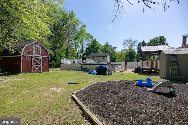 view of yard with a storage shed, fence, an outbuilding, and a playground