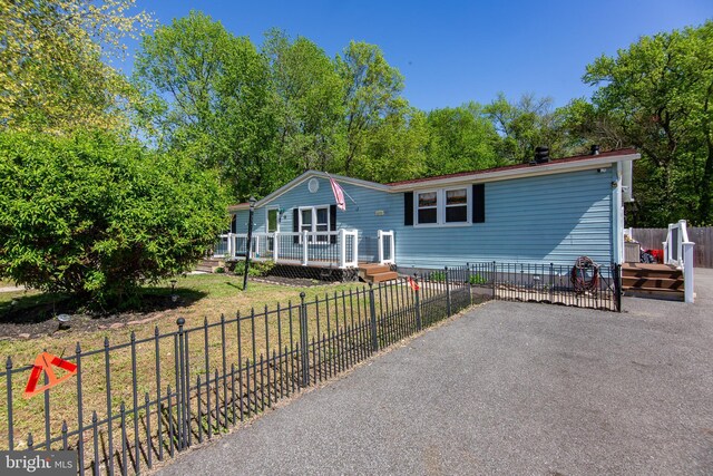 manufactured / mobile home featuring a deck, fence, and a patio area