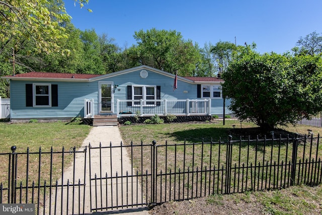 manufactured / mobile home featuring a fenced front yard and a front yard