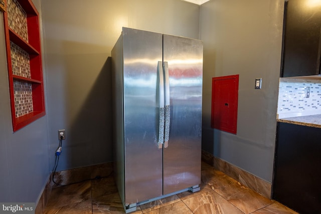 kitchen with baseboards, tasteful backsplash, and freestanding refrigerator
