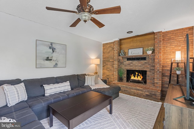 living room with a fireplace, a ceiling fan, brick wall, and wood finished floors