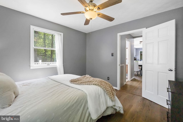 bedroom featuring baseboards, dark wood-style flooring, and ceiling fan