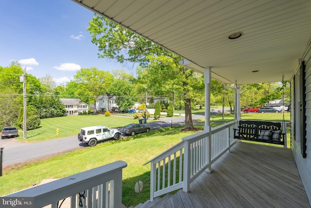 deck featuring covered porch and a lawn
