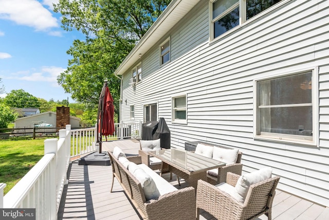 deck with an outdoor living space, a lawn, and fence