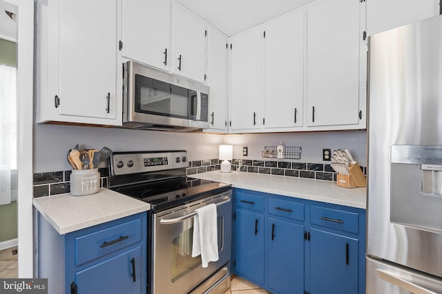 kitchen with light countertops, stainless steel appliances, blue cabinetry, and light tile patterned flooring