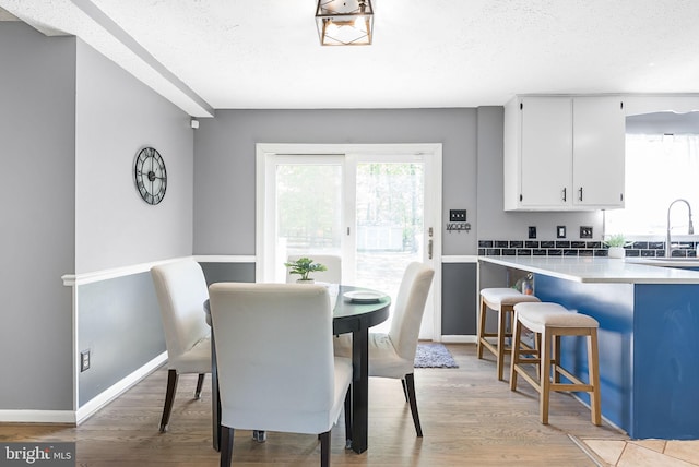7819 Oak St, Manassas, VA 20111 - dining space featuring a textured ceiling, baseboards, and light wood finished floors