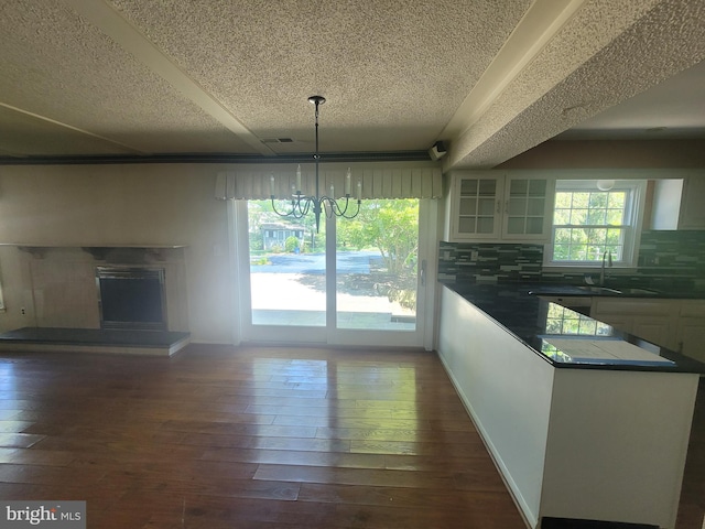5895 Tibby Rd, Bensalem, PA 19020 - kitchen featuring a textured ceiling, a sink, white cabinets, a chandelier, and glass insert cabinets
