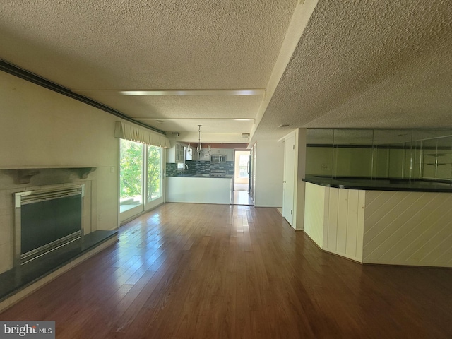 5895 Tibby Rd, Bensalem, PA 19020 - unfurnished living room with a textured ceiling, wood finished floors, and a glass covered fireplace