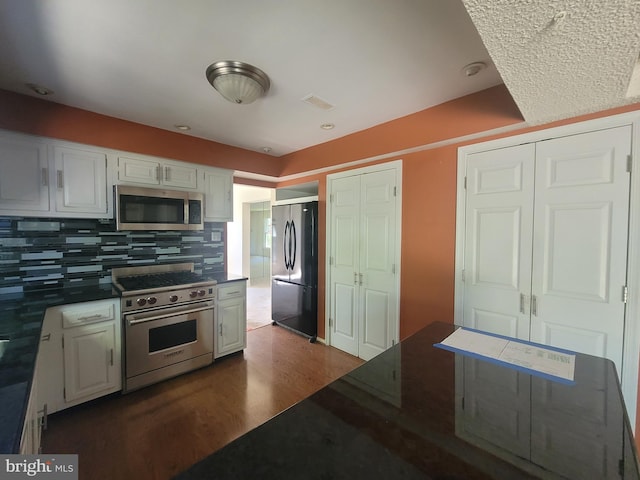 5895 Tibby Rd, Bensalem, PA 19020 - kitchen with appliances with stainless steel finishes, dark wood-style flooring, decorative backsplash, and white cabinets