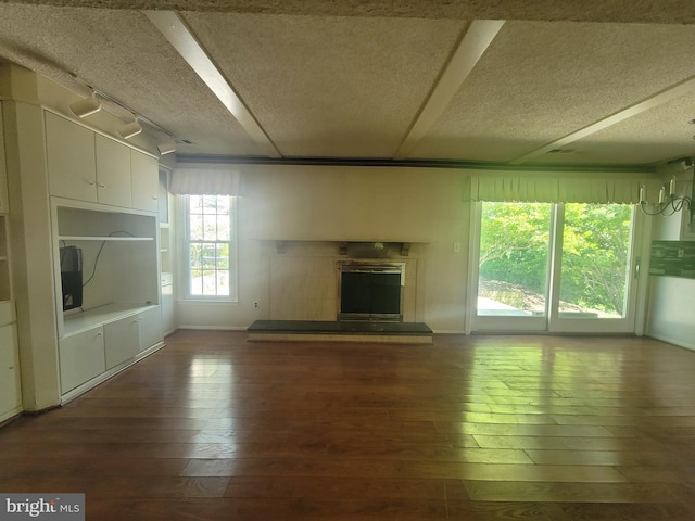5895 Tibby Rd, Bensalem, PA 19020 - unfurnished living room featuring dark wood-style floors, a glass covered fireplace, and a textured ceiling