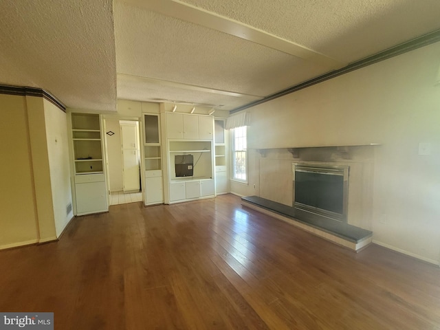 5895 Tibby Rd, Bensalem, PA 19020 - unfurnished living room with a textured ceiling, wood finished floors, a glass covered fireplace, and baseboards