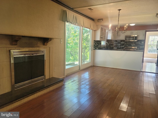 5895 Tibby Rd, Bensalem, PA 19020 - unfurnished living room featuring a textured ceiling, a chandelier, a sink, and dark wood-style floors
