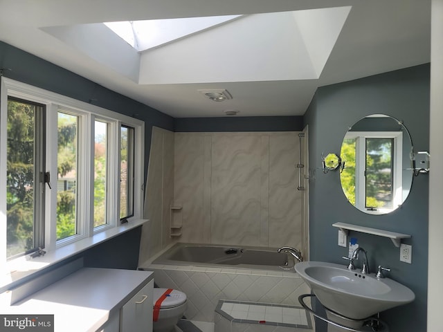 5895 Tibby Rd, Bensalem, PA 19020 - bathroom featuring a skylight, tiled tub, toilet, and a sink