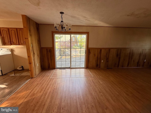 2218 Trenton Ave, Bristol, PA 19007 - unfurnished dining area with light wood-style floors, a chandelier, wood walls, a textured ceiling, and wainscoting