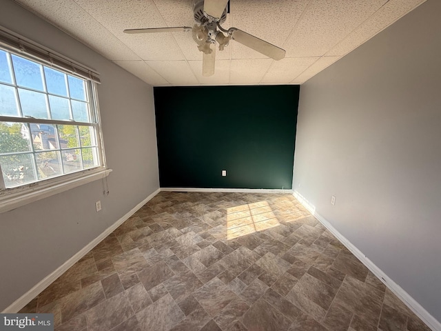 2218 Trenton Ave, Bristol, PA 19007 - spare room featuring baseboards, stone finish flooring, a ceiling fan, and a paneled ceiling