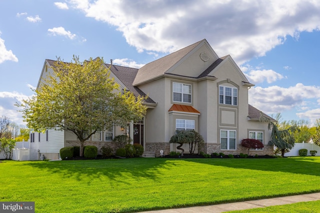 traditional home featuring fence, stucco siding, and a front yard