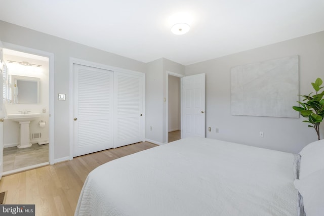 817 Golden Arrow St, Great Falls, VA 22066 - bedroom with wood finished floors, ensuite bathroom, baseboards, a closet, and a sink