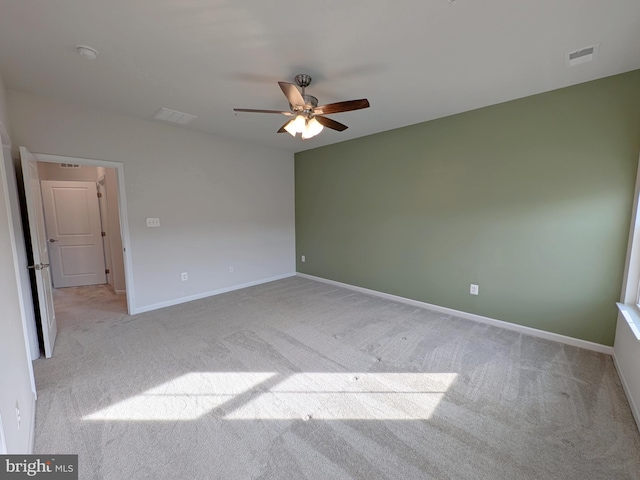 unfurnished room with visible vents, a ceiling fan, baseboards, and light carpet