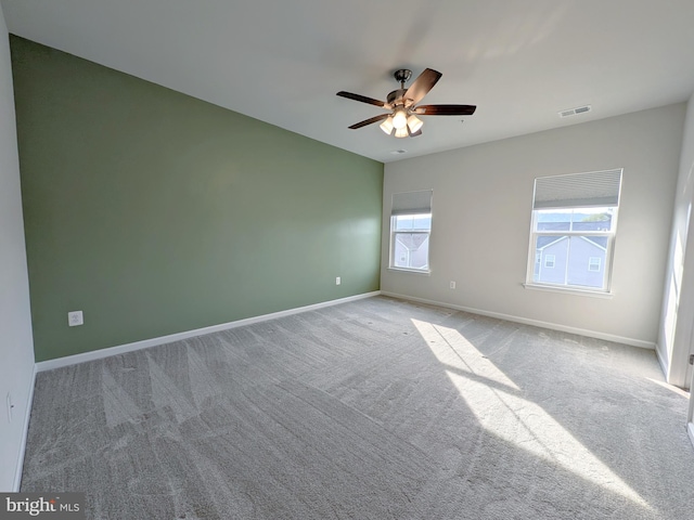 empty room with a ceiling fan, baseboards, visible vents, and carpet