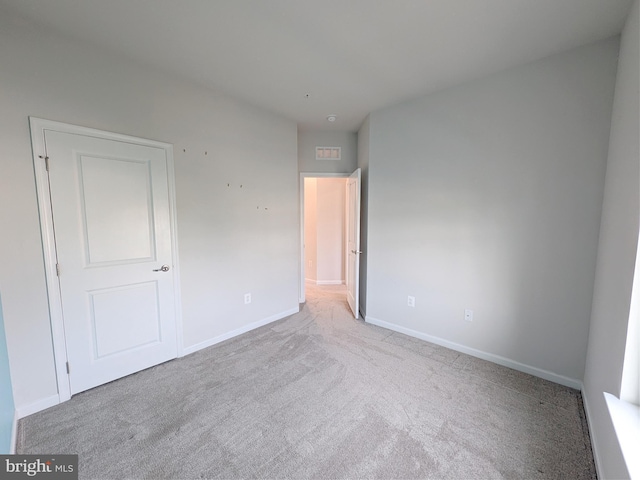 unfurnished bedroom featuring baseboards and carpet