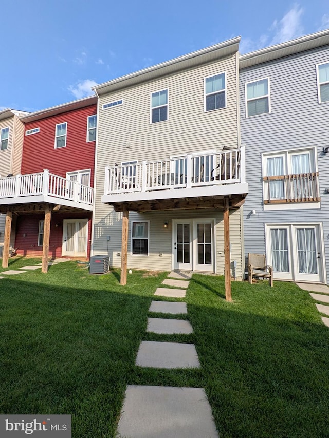 back of property with a yard and central AC unit