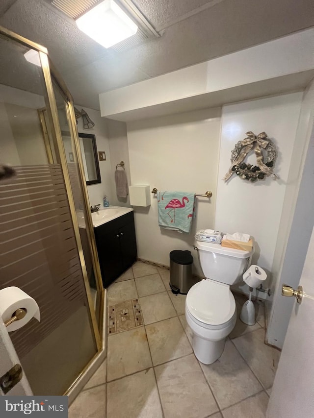 bathroom with vanity, toilet, tile patterned floors, and a stall shower