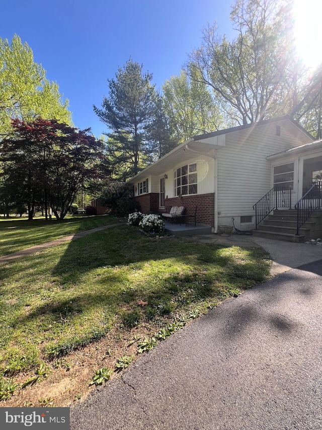 view of property exterior featuring a lawn and brick siding