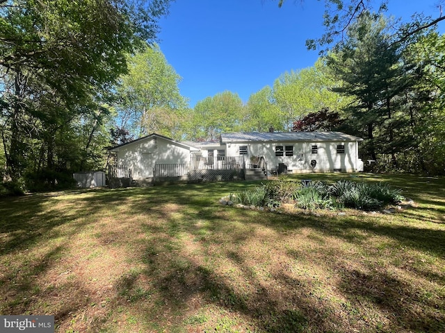 back of property with a lawn and a wooden deck