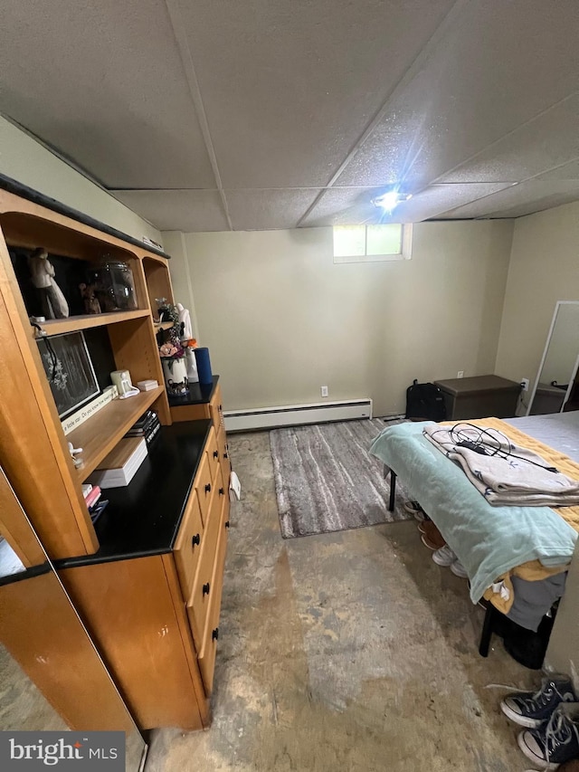 interior space with baseboard heating, concrete flooring, and a drop ceiling