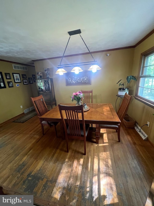 dining area featuring baseboards, ornamental molding, wood-type flooring, and visible vents