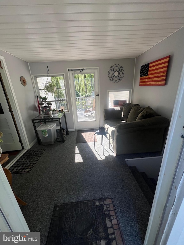 carpeted living area with wooden ceiling