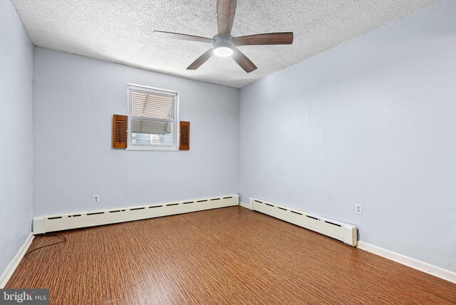 spare room with baseboards, a ceiling fan, a textured ceiling, and baseboard heating