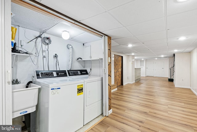 laundry area with independent washer and dryer, laundry area, a sink, baseboards, and light wood-type flooring