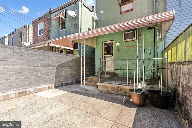 back of property featuring a patio area, a fenced backyard, a wall mounted air conditioner, and stucco siding