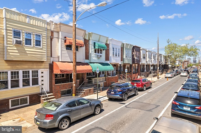 view of street with a residential view, sidewalks, entry steps, and street lighting