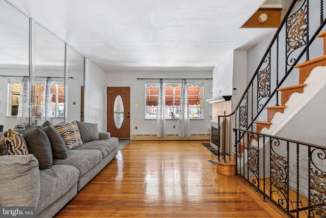 living room featuring wood-type flooring, stairs, and a healthy amount of sunlight