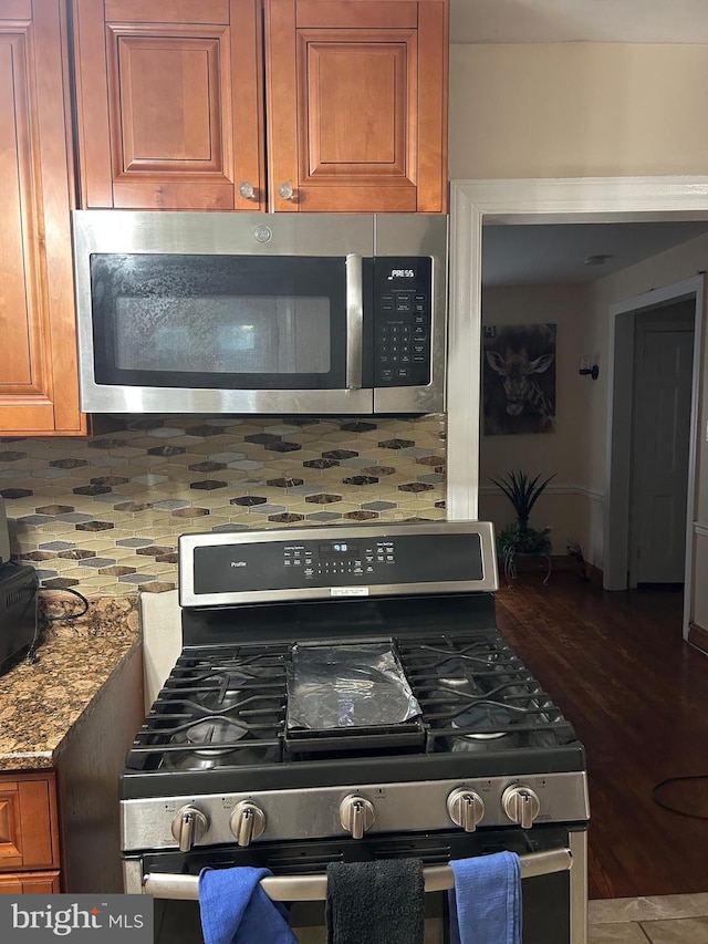 547 Baeder Rd, Jenkintown, PA 19046 - kitchen view of appliances with stainless steel finishes, backsplash, brown cabinets, and light stone countertops