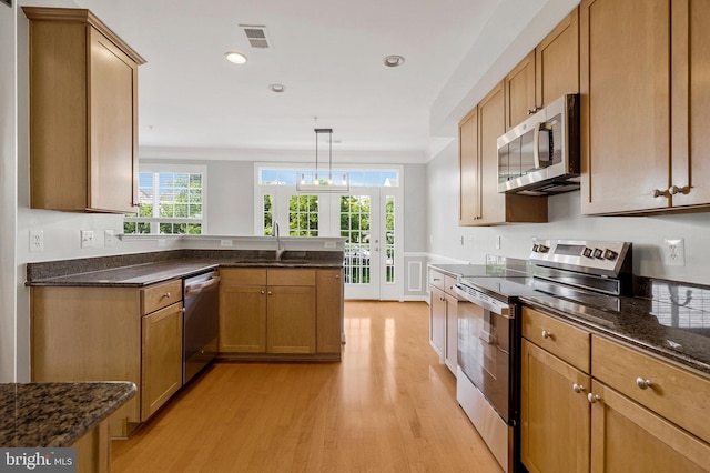 kitchen featuring a sink, stainless steel appliances, light wood-style flooring, and a wealth of natural light