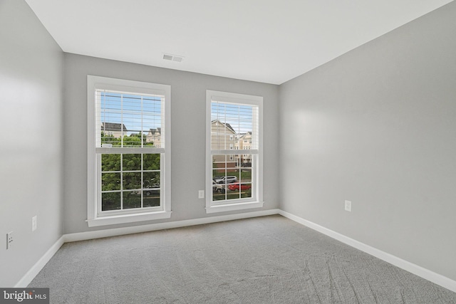 unfurnished room with carpet flooring, baseboards, and visible vents