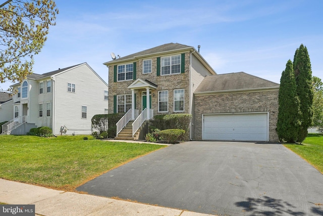 colonial inspired home featuring brick siding, driveway, a front yard, and a garage