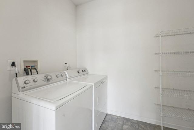 clothes washing area with laundry area, baseboards, and washer and dryer