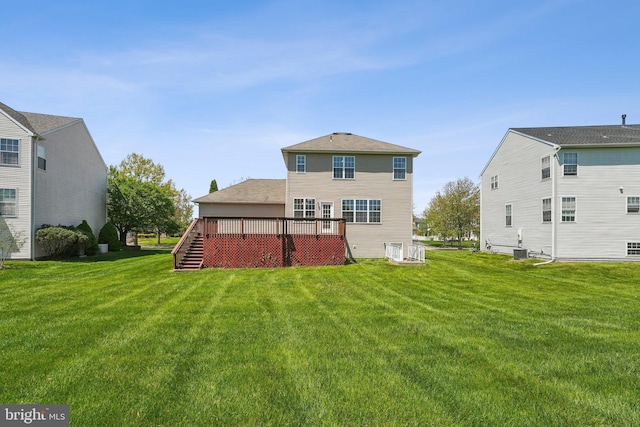 back of house with stairs, a yard, and a deck