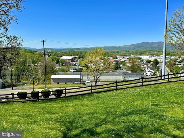 view of community featuring fence, a mountain view, and a yard