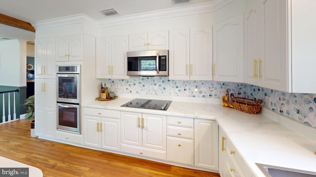 kitchen with visible vents, white cabinetry, tasteful backsplash, and stainless steel appliances