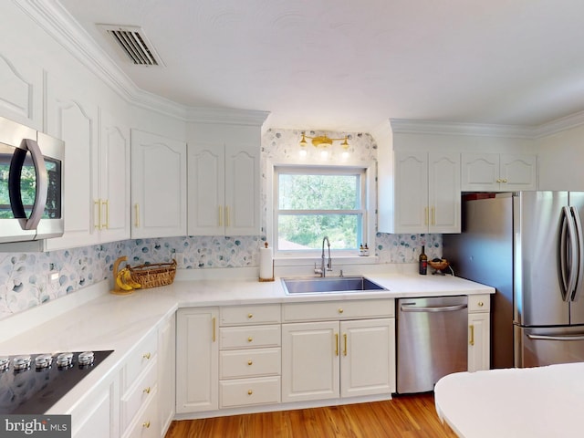 kitchen with a sink, backsplash, stainless steel appliances, and visible vents
