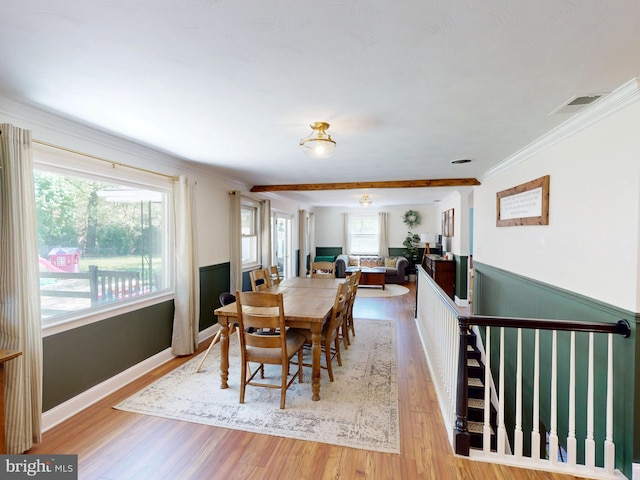 dining room featuring baseboards, ornamental molding, light wood finished floors, and visible vents