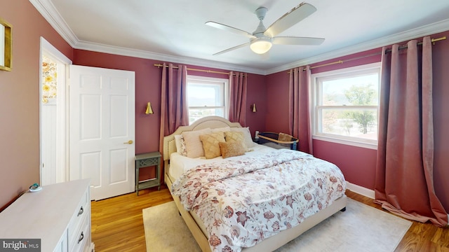 bedroom featuring ornamental molding, light wood finished floors, and a ceiling fan