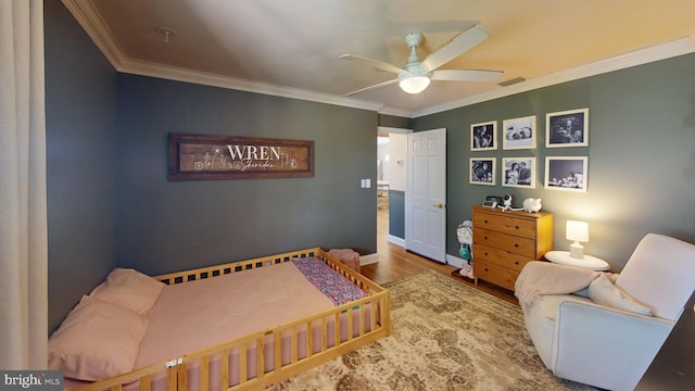 bedroom featuring ceiling fan, ornamental molding, and wood finished floors