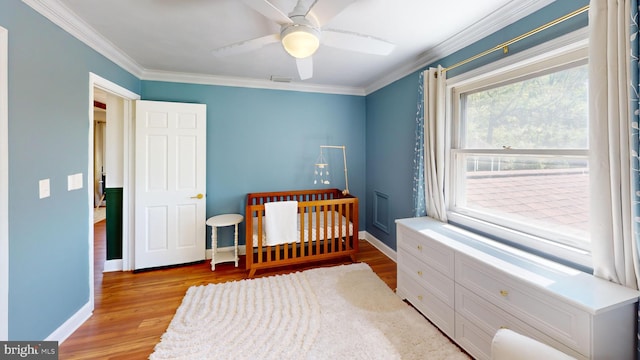 bedroom featuring crown molding, visible vents, light wood-style floors, baseboards, and ceiling fan