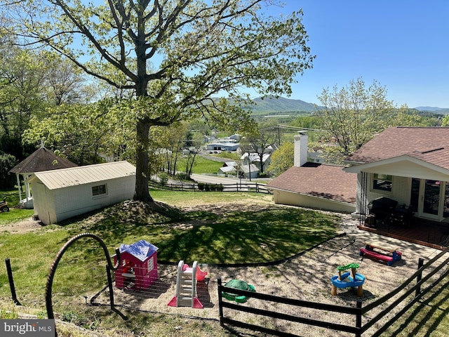 view of yard featuring fence and a mountain view